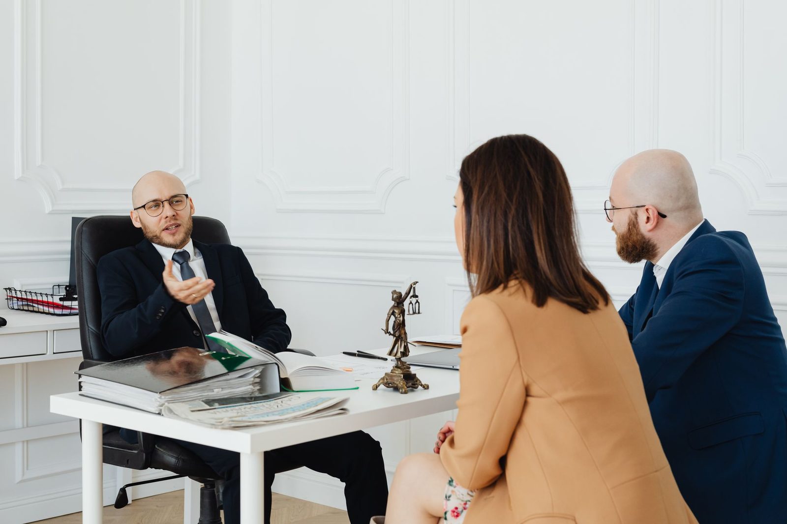Adults reviewing legal documents at a conference table in an office setting.