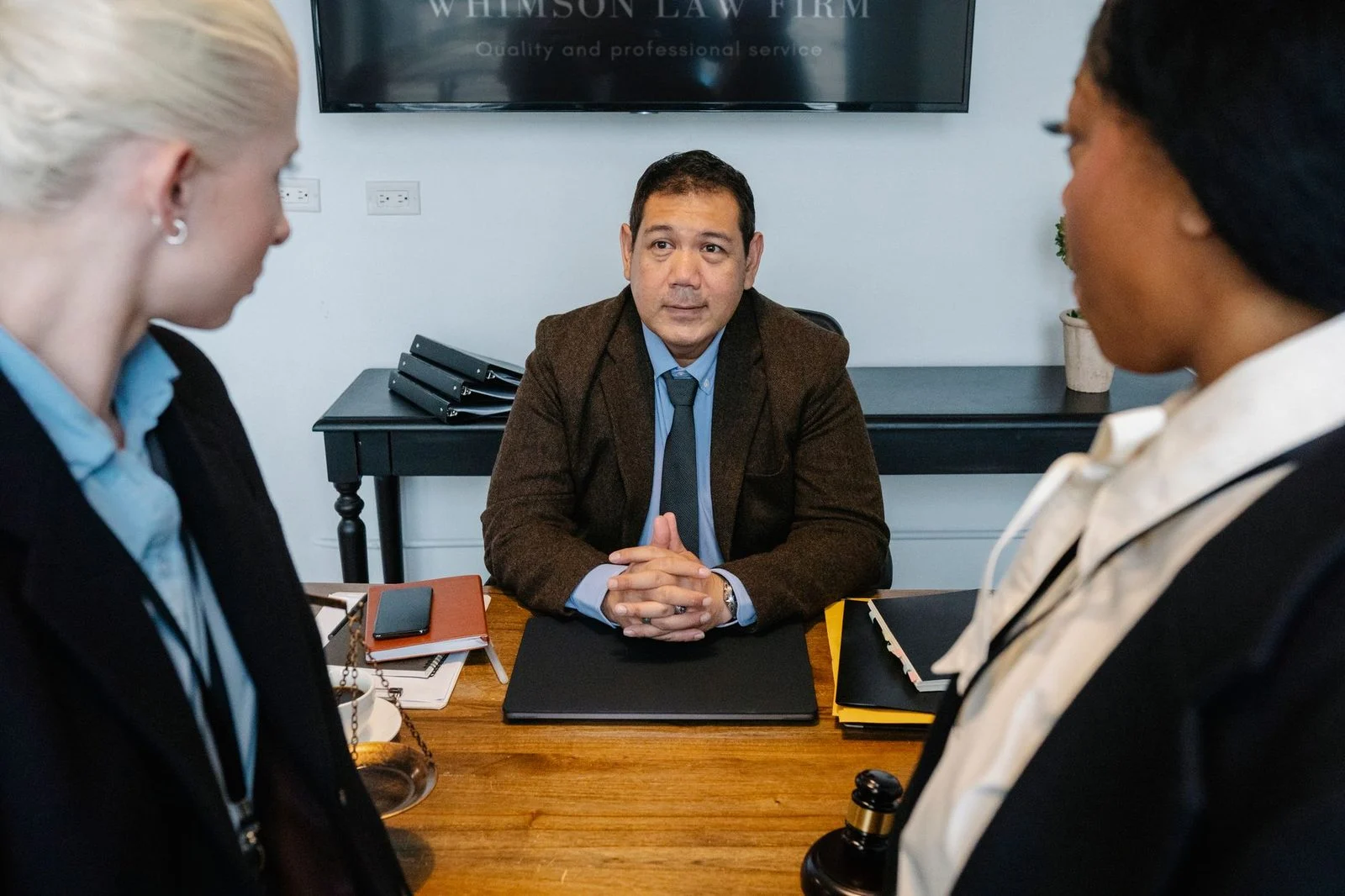 Diverse professionals discussing legal strategy at a conference table in a law office.