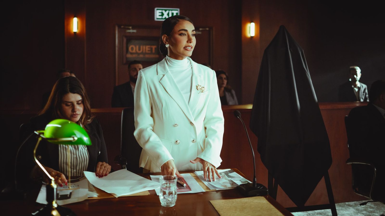 Female lawyer in white suit presenting case in courtroom.