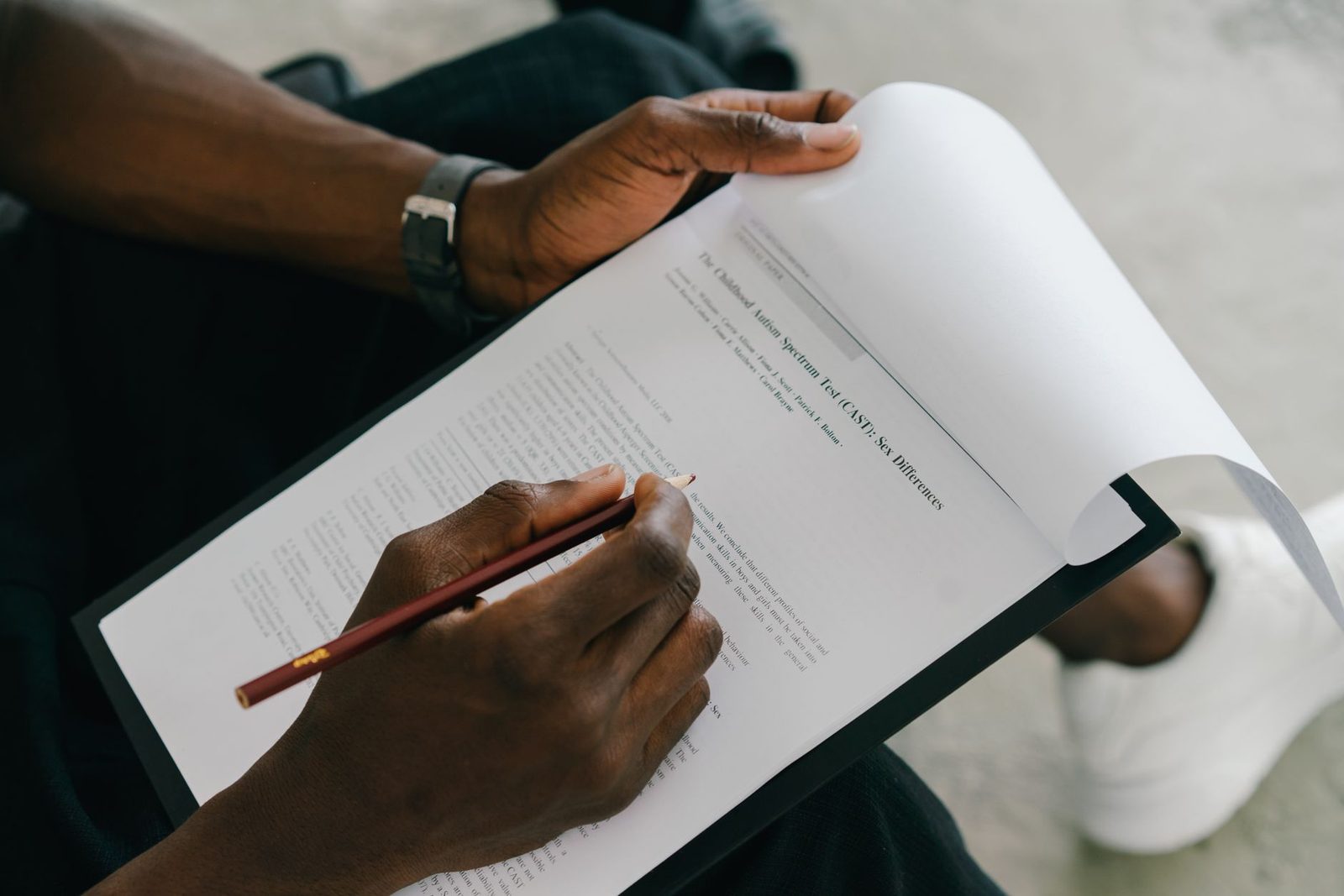 Person completing a psychological assessment form with a pencil.
