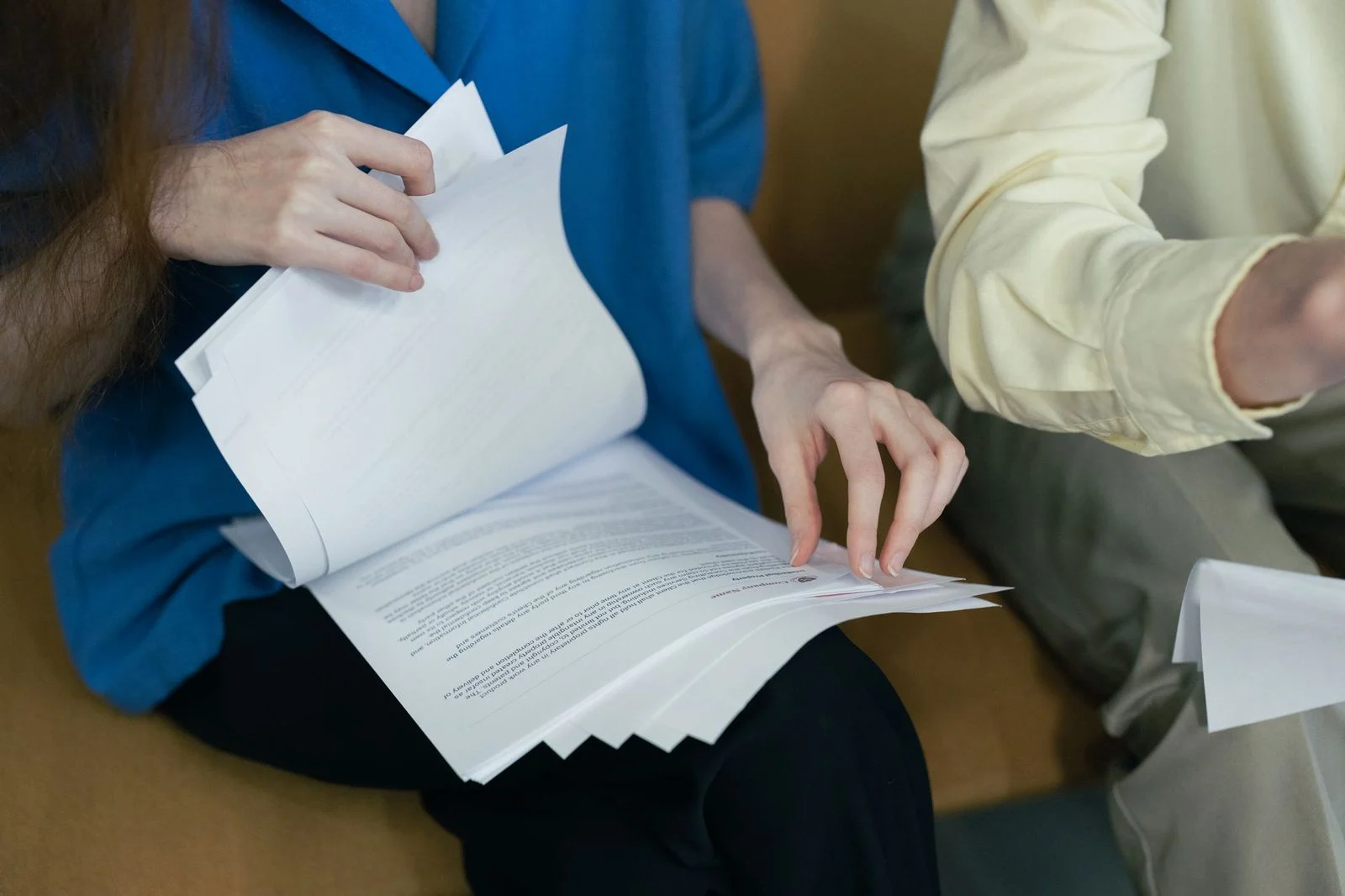 Professionals reviewing legal documents together on a sofa.