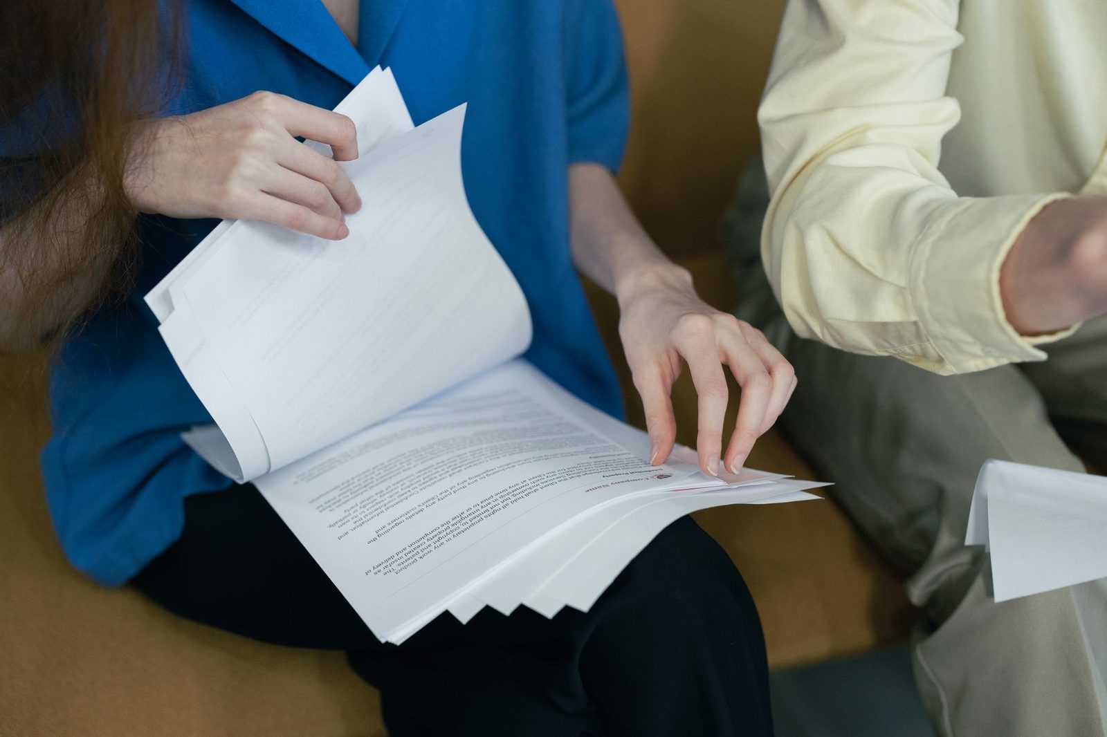 Professionals reviewing legal documents together on a sofa.