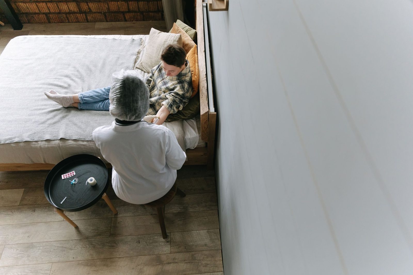 A doctor attends to a young patient in a cozy bedroom.