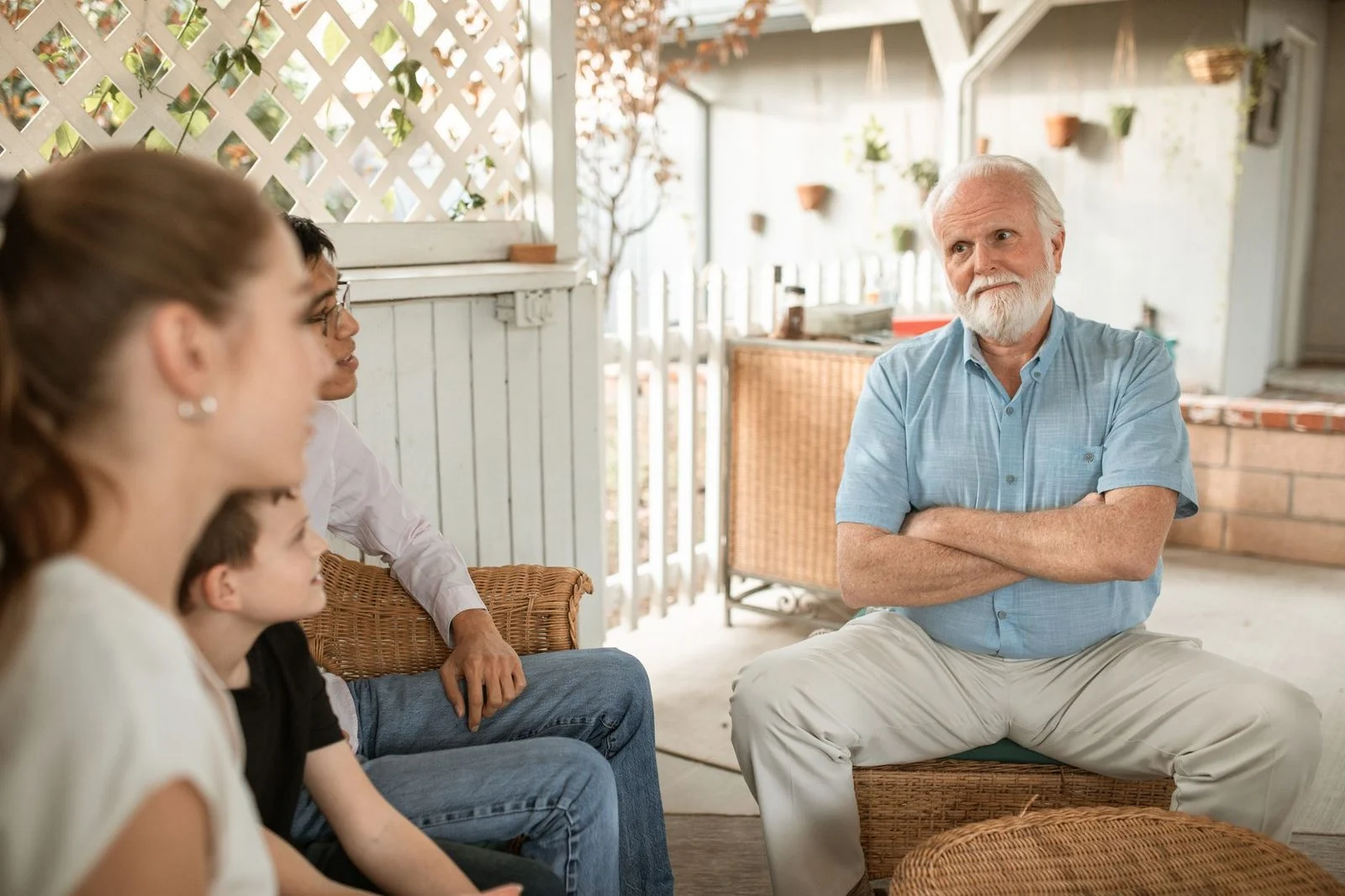 Una familia sentada en el interior, conversando de cerca y sonriendo.