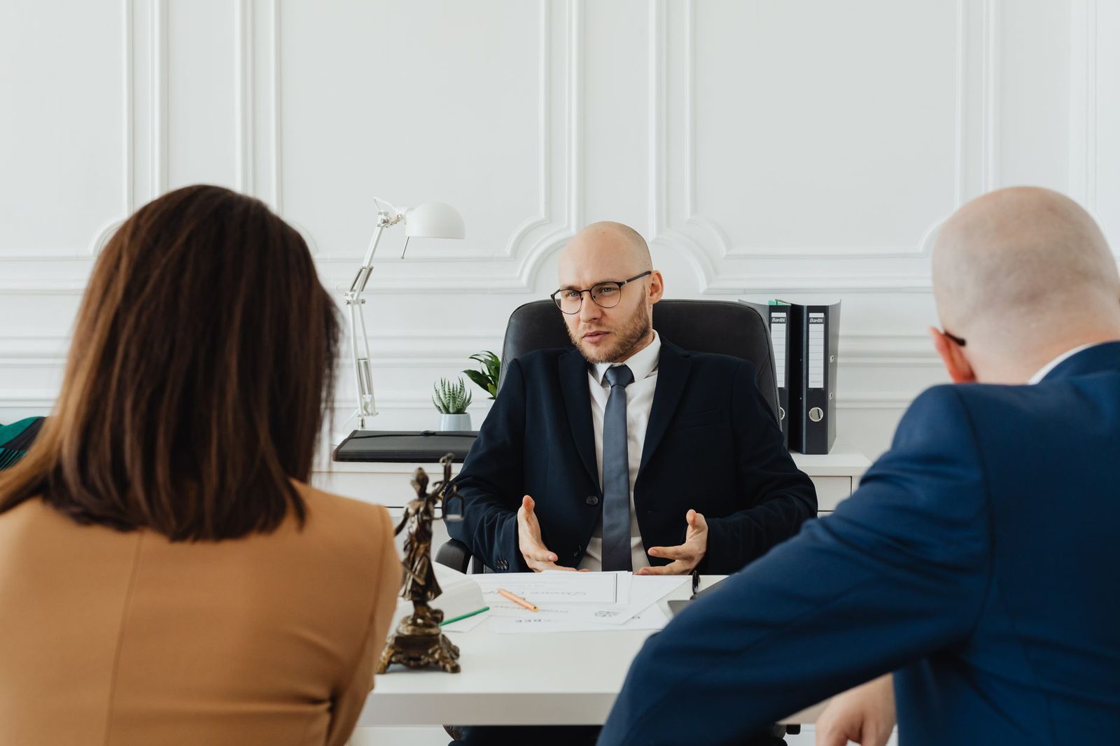 A lawyer and clients meet at a table in a modern office.