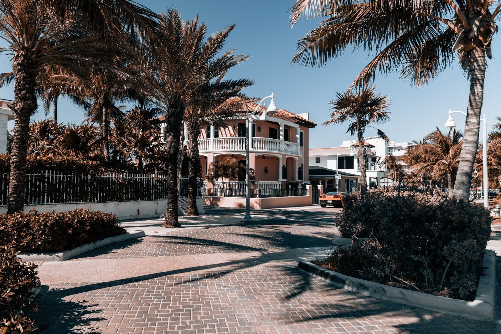 Casa tropical rodeada de palmeras en una calle soleada de Hollywood, Florida.