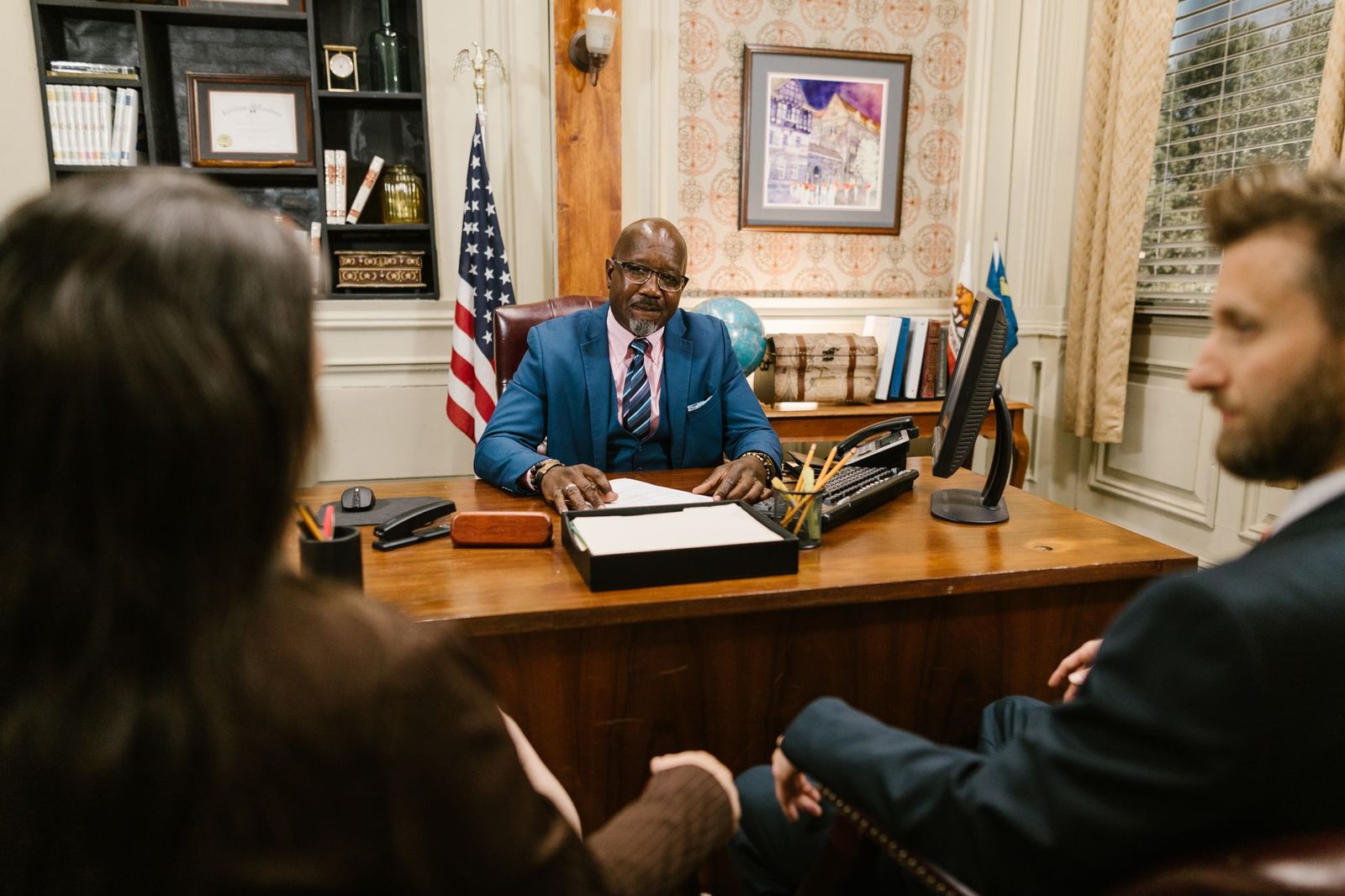Lawyer discussing case details with clients at office desk during consultation.