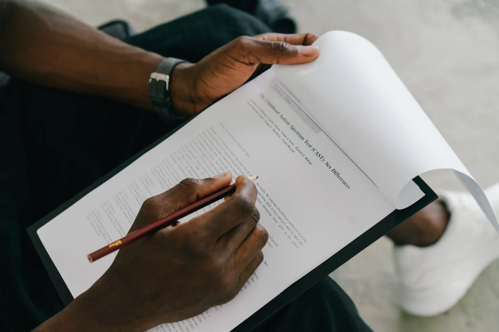 Person completing a psychological assessment form with a pencil.