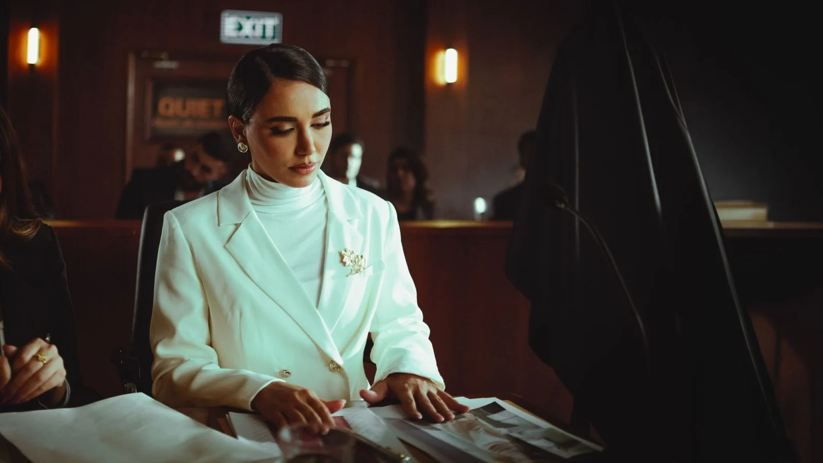 Mujer con expresión concentrada revisando documentos en una sala de tribunal.