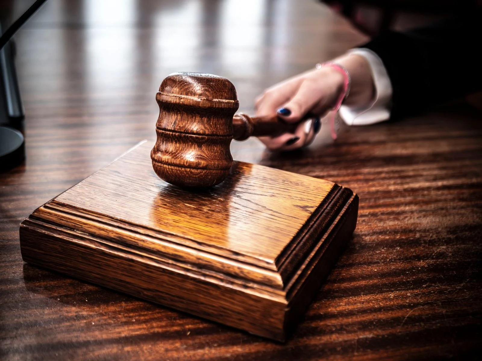 Wooden gavel resting on a judge's desk.